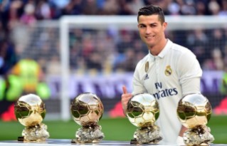 TOPSHOT - Real Madrid s Portuguese forward Cristiano Ronaldo poses with his four Ballon d Or France Football trophies before the Spanish league football match Real Madrid CF vs Granada FC at the Santiago Bernabeu stadium in Madrid on January 7 2017 AFP PHOTO GERARD JULIEN